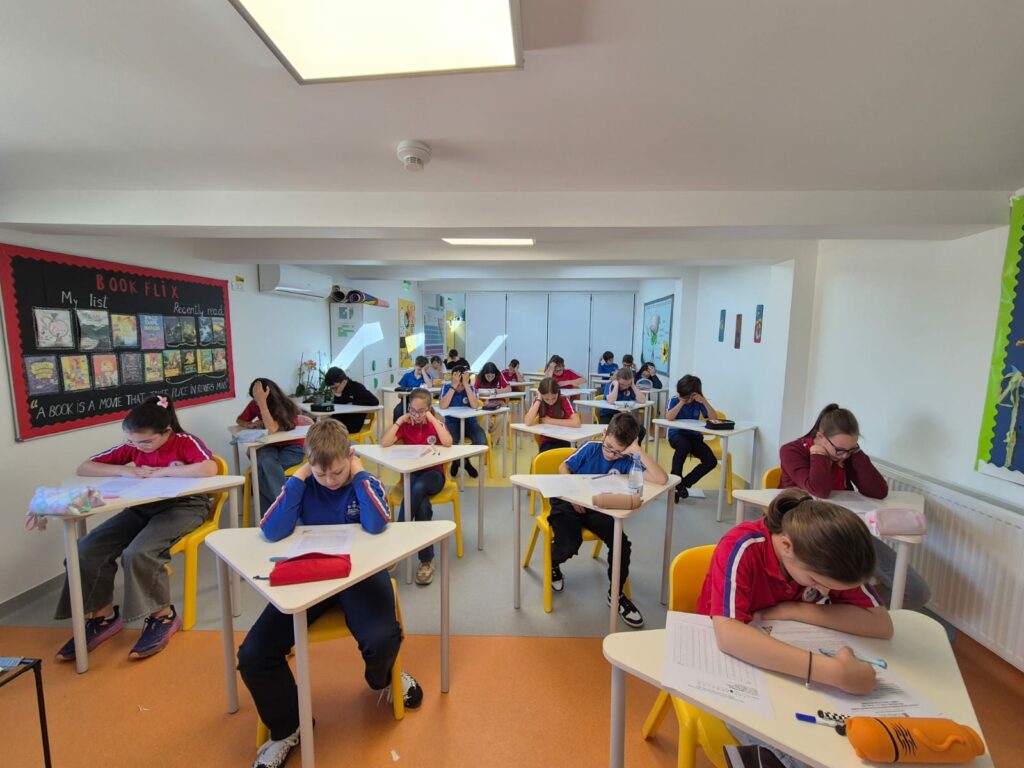 Elev concentrat lucrând la un proiect școlar dezvoltând rezistența la efort alături de un profesor