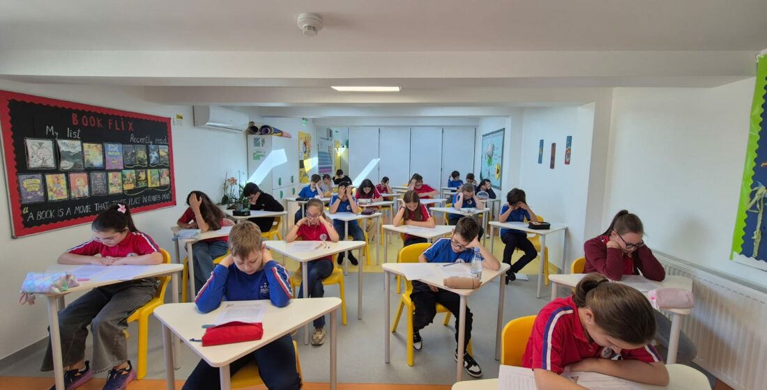 Elev concentrat lucrând la un proiect școlar dezvoltând rezistența la efort alături de un profesor