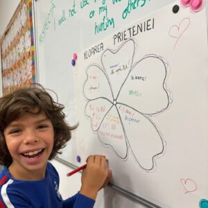 Un grup de copii fericiți într-o sală de clasă luminoasă, demonstrând puterea zâmbetului în educație.