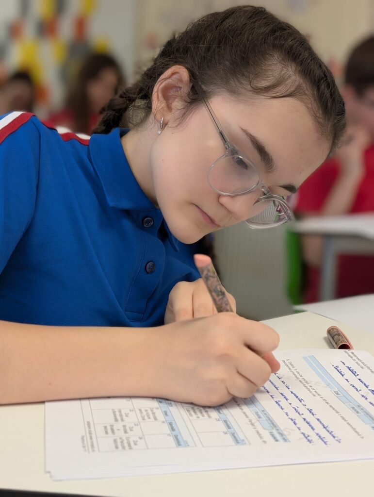 Elevi curioși participând la o activitate de învățare experiențială în afara sălii de clasă, explorând lumea alături de profesori.